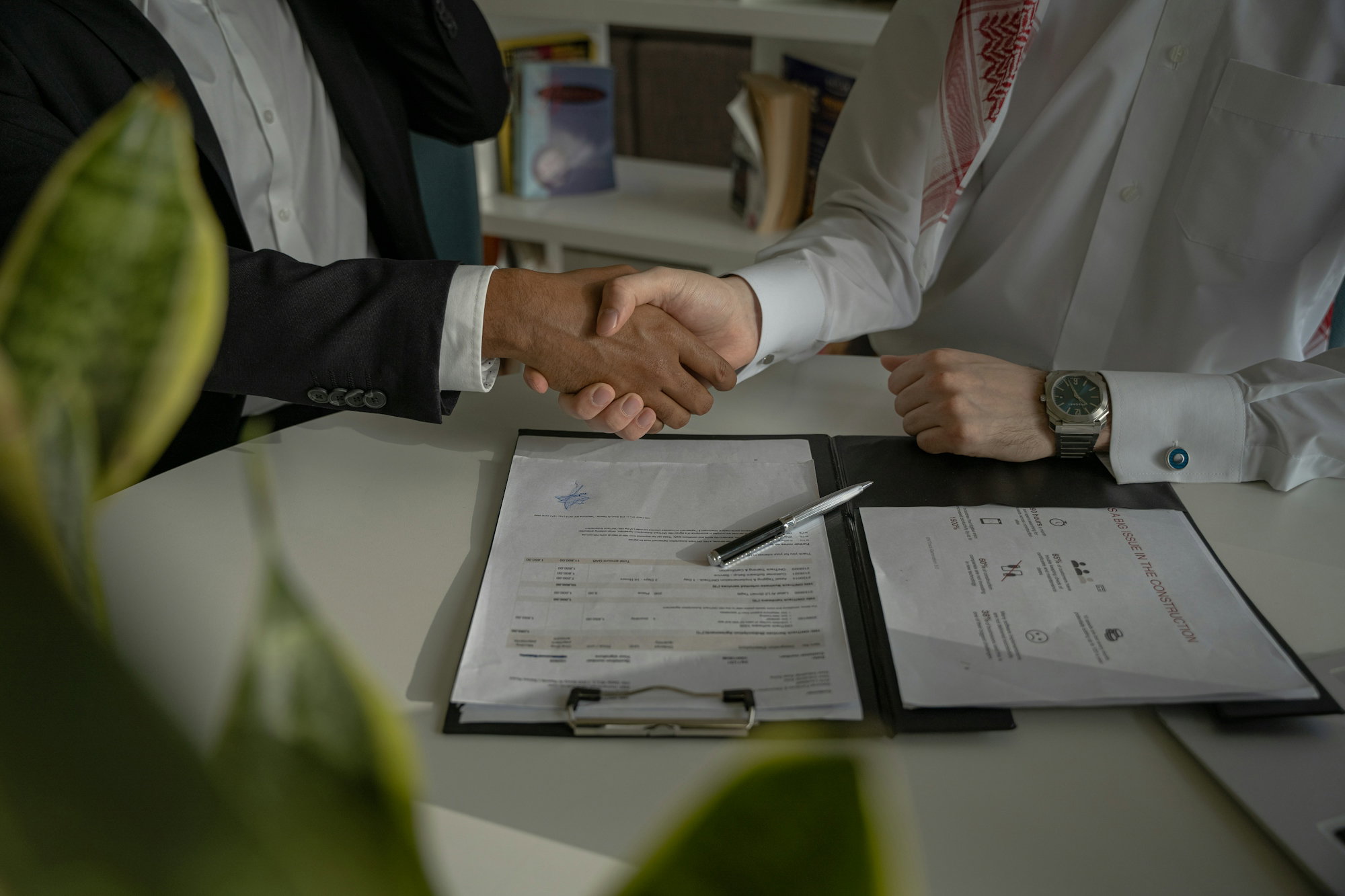 two-people-shaking-hands-over-a-piece-of-paper.jpg two people shaking hands over a piece of paper